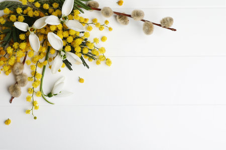 Beautiful floral composition with mimosa flowers on white wooden background, flat lay. Space for textの写真素材