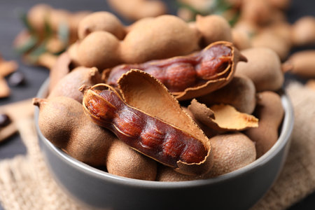 Delicious ripe tamarinds in ceramic bowl on table, closeupの写真素材