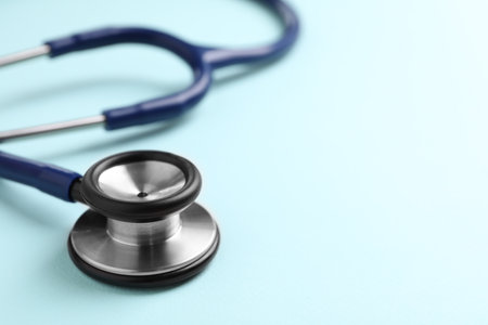 Stethoscope on light blue background, closeup. Space for textの写真素材