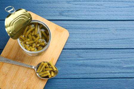 Canned green beans on blue wooden table, top view. Space for textの写真素材