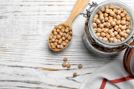 Raw chickpeas on white wooden table, flat lay. Space for textの写真素材