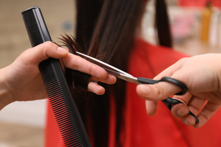 Stylist cutting hair of client in professional salon, closeupの写真素材
