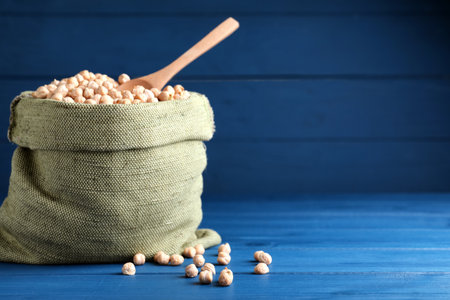 Raw chickpeas in bowl on blue wooden table. Space for textの写真素材