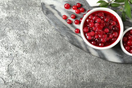 Flat lay composition with cranberry sauce and fresh berries on gray table, space for textの写真素材