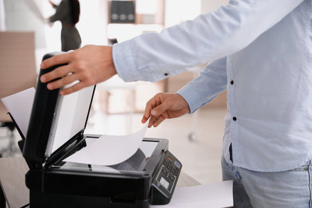 Employee using modern printer in office, closeupの写真素材