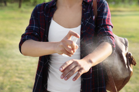 Woman applying insect repellent onto arm outdoors, closeupの写真素材