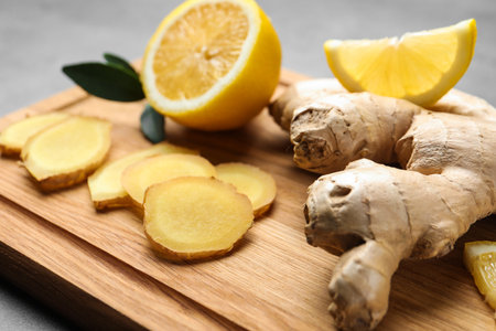 Fresh lemon and ginger on wooden board, closeup