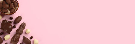 Flat lay composition with chocolate Easter bunnies, eggs and candies on pink background. Space for textの写真素材