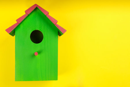 Beautiful bird house on yellow background, top view. Space for textの写真素材