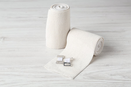 Medical bandage rolls on white wooden tableの写真素材