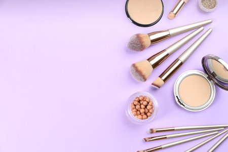 Flat lay composition with makeup brushes on violet background, space for textの写真素材
