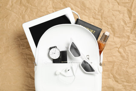 Stylish urban backpack with different items on parchment paper, top viewの写真素材