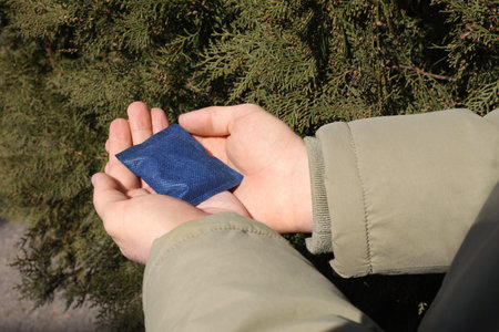 Man holding hand warmer outdoors, closeup viewの写真素材