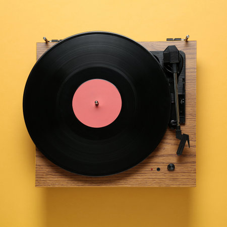 Modern turntable with vinyl record on orange background, top viewの写真素材
