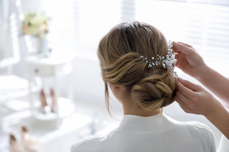 Professional stylist making wedding hairstyle for bride in salon, back viewの写真素材