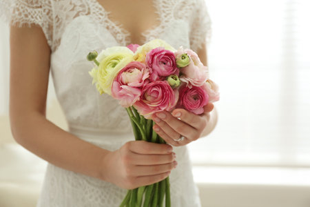 Bride with beautiful ranunculus bouquet indoors, closeupの写真素材