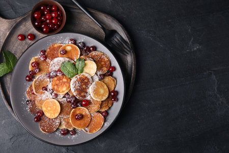 Cereal pancakes with cranberries served on black table, top view. Space for textの写真素材