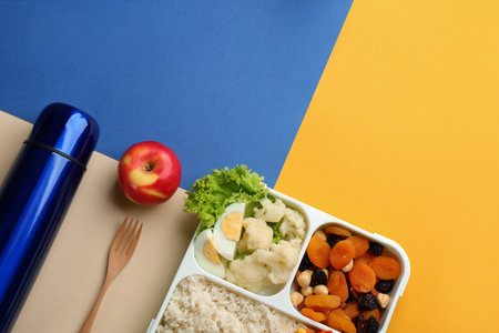 Thermo and lunch box with food on color background, flat lay. Space for textの写真素材