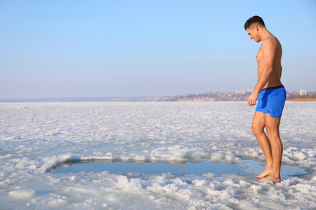 Man near ice hole on winter day. Baptist ritualの写真素材
