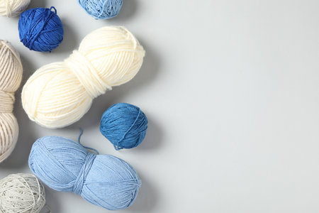 Soft colorful woolen yarns on white background, flat lay. Space for textの写真素材