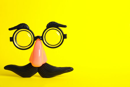 Funny face made with clown's accessories on yellow background, space for textの写真素材