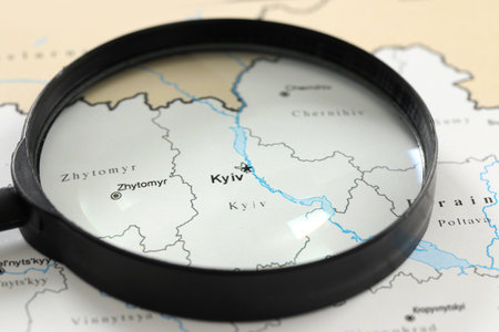 MYKOLAIV, UKRAINE - NOVEMBER 09, 2020: Kyiv city marked on map of Ukraine, view through magnifying glassの写真素材