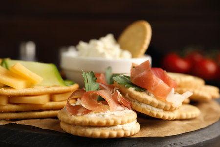 Various snacks with salted crackers on wooden board, closeupの写真素材