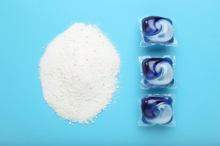 Laundry capsules and washing powder on turquoise background, flat layの写真素材