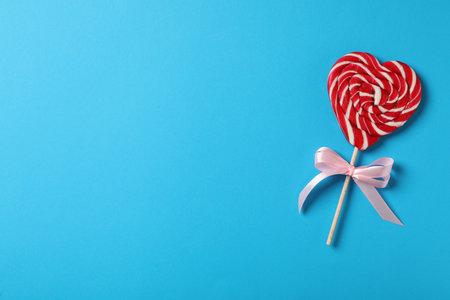 Sweet heart shaped lollipop on light blue background, top view with space for text. Valentine's day celebrationの写真素材