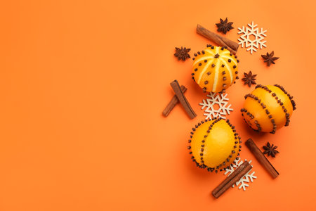 Flat lay composition with pomander balls made of fresh citrus fruits on orange background. Space for textの写真素材