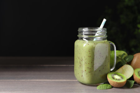 Delicious kiwi smoothie and ingredients on wooden table. Space for textの写真素材