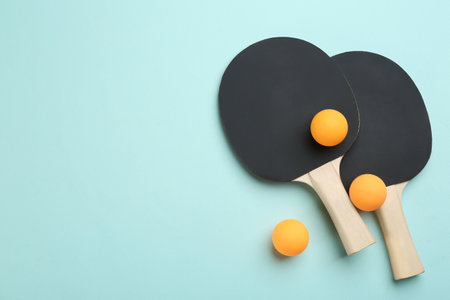 rackets and balls on turquoise background, flat lay. Space for textの写真素材