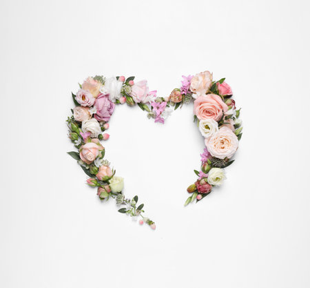 Beautiful heart made of different flowers on white background, top viewの写真素材