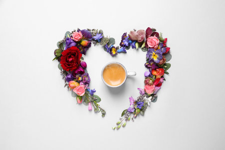 Beautiful heart shaped floral composition with cup of coffee on light background, flat layの写真素材