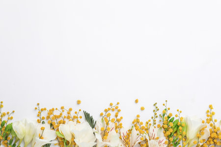 Beautiful floral composition with mimosa flowers on white background, flat lay. Space for textの写真素材