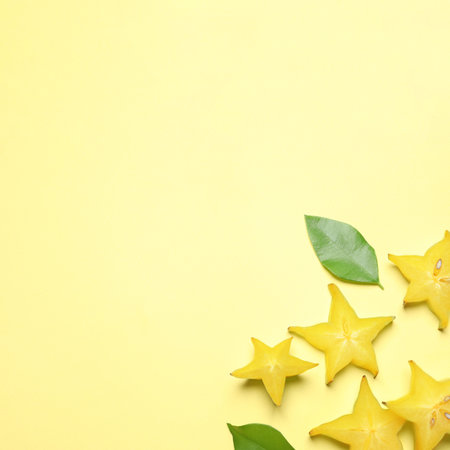 Delicious carambola slices on yellow background, flat lay. Space for textの写真素材