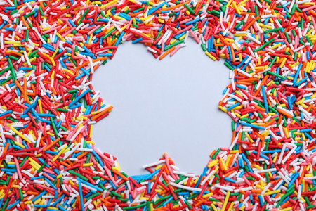 Frame of colorful sprinkles on light gray background, flat lay with space for text. Confectionery decorの写真素材
