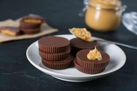 Delicious peanut butter cups on black tableの写真素材