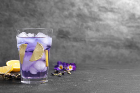 Organic blue Anchan with lemon in glass on gray table, space for text. herbal teaの写真素材