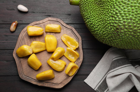 Fresh exotic jackfruit on black wooden table, flat layの写真素材