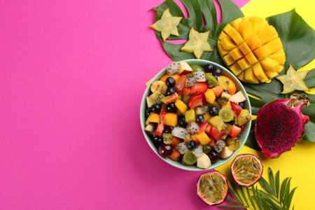 Flat lay composition with delicious exotic fruit salad on color background. Space for textの写真素材