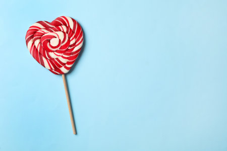 Sweet heart shaped lollipop on light blue background, top view with space for text. Valentine's day celebrationの写真素材
