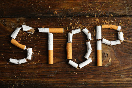 Word Stop of cut cigarettes on wooden table, flat lay. Quitting smoking conceptの写真素材