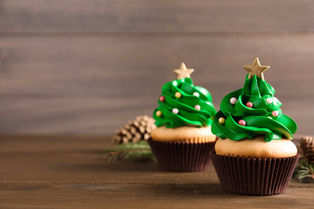 Christmas tree shaped cupcakes on wooden table. Space for textの写真素材
