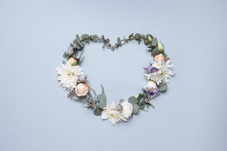 Beautiful heart made of different flowers on light gray background, flat lay. Space for textの写真素材