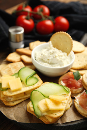Various snacks with salted crackers on wooden board, closeupの写真素材