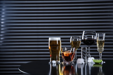 Many different alcoholic drinks on table against dark background. Space for textの写真素材