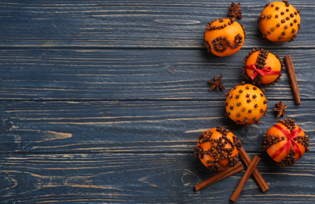 Flat lay composition with pomander balls made of fresh tangerines and cloves on blue wooden table, space for textの写真素材