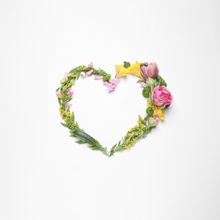 Beautiful heart made of different flowers on white background, top viewの写真素材