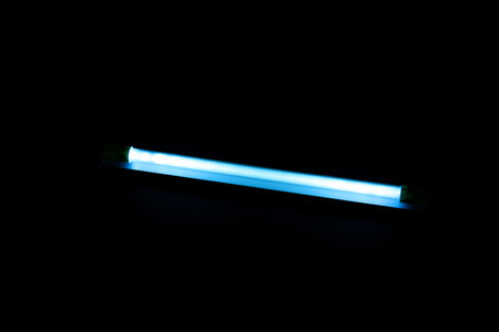 Modern ultraviolet lamp glowing on black backgroundの写真素材